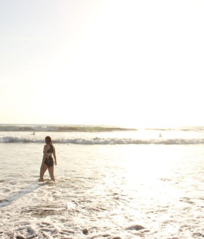 girl standing in the ocean by the shore