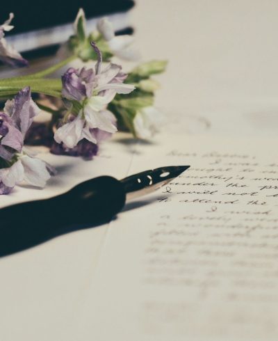 ink pen with purple flowers sitting on a piece of paper